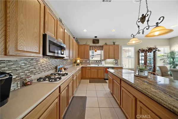 a kitchen with stainless steel appliances a sink a stove top oven a counter space and cabinets