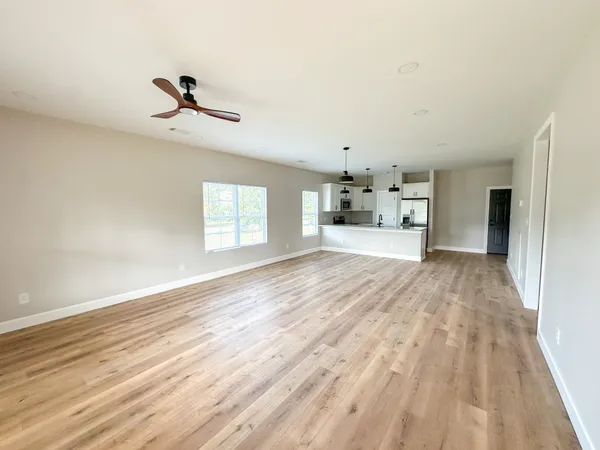 a view of empty room with wooden floor and window