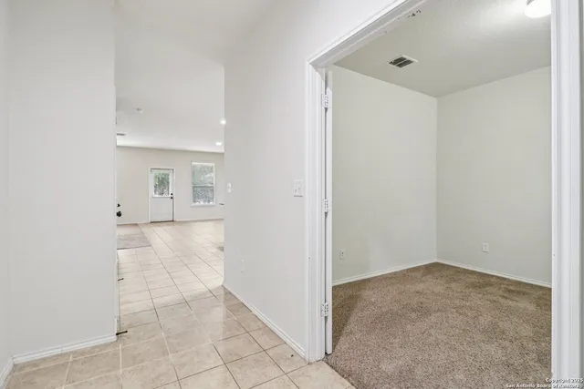 an empty room with white walls and windows