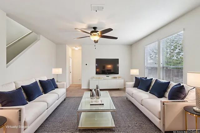 a living room with furniture a flat screen tv and a large window