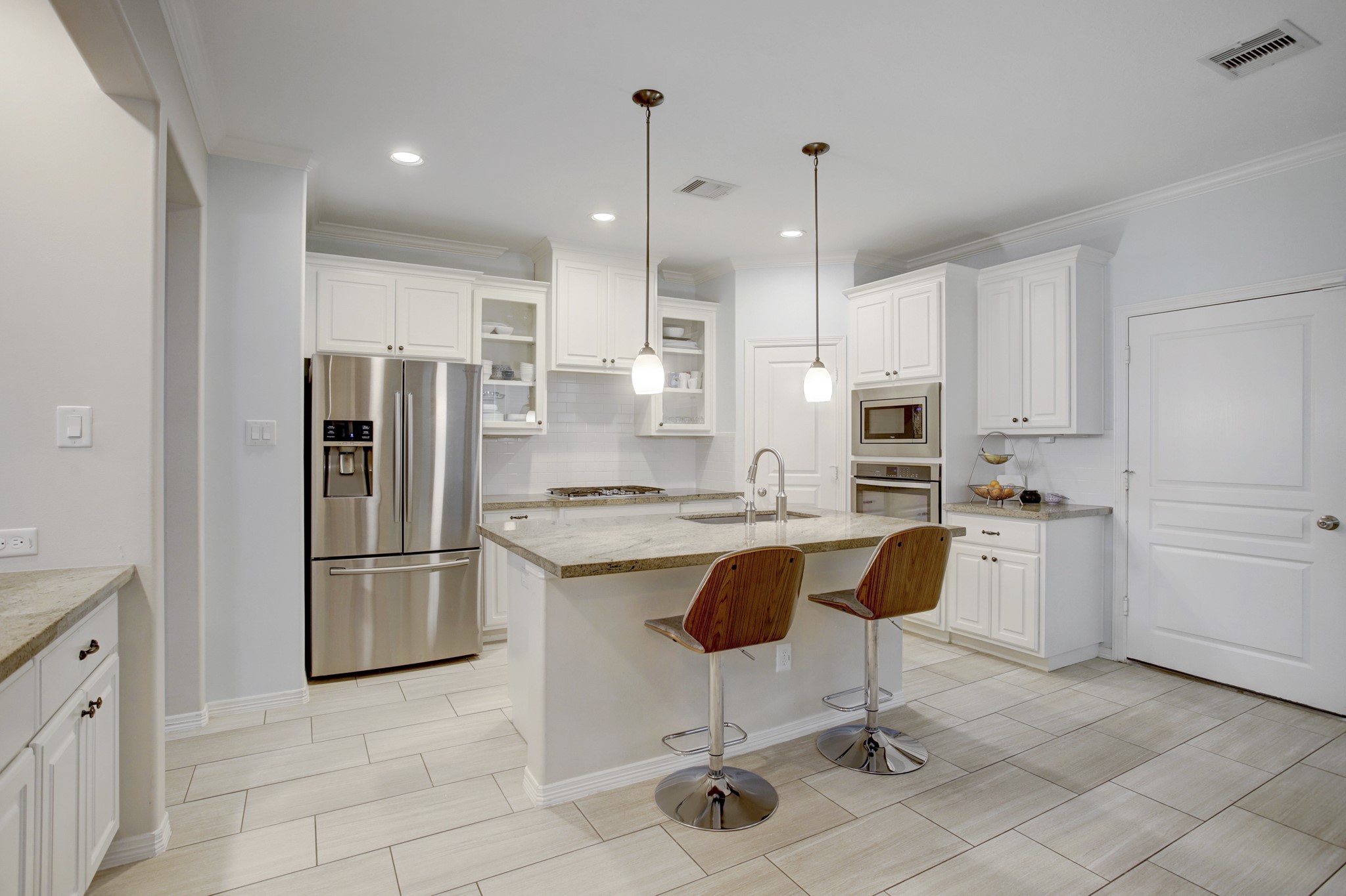 4230 Drake Street Houston, TX 77005 - Photo 9 of 38 Kitchen - This gourmet kitchen is truly a chef’s delight! It is loaded with upgraded/functional features: granite countertops, custom cabinetry, stainless steel hardware, undercabinet lighting, a subway tile backsplash, sufficient storage to house your kitchen appliances and ample prep space for the consummate chef!