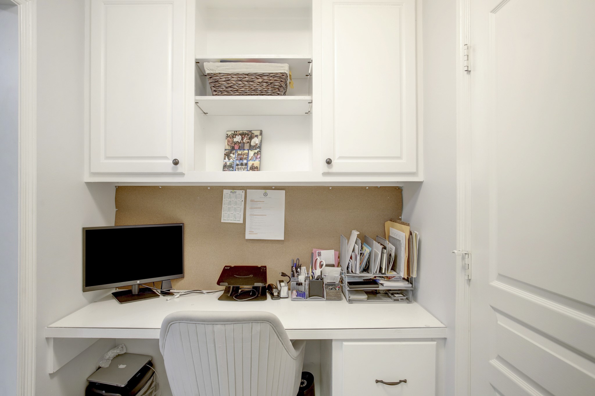 4230 Drake Street Houston, TX 77005 - Photo 16 of 38 Primary Suite Workspace – This built-in desk with shelves, cabinets and drawers is located between the primary bedroom and bathroom. This casual workspace can help keep you organized.