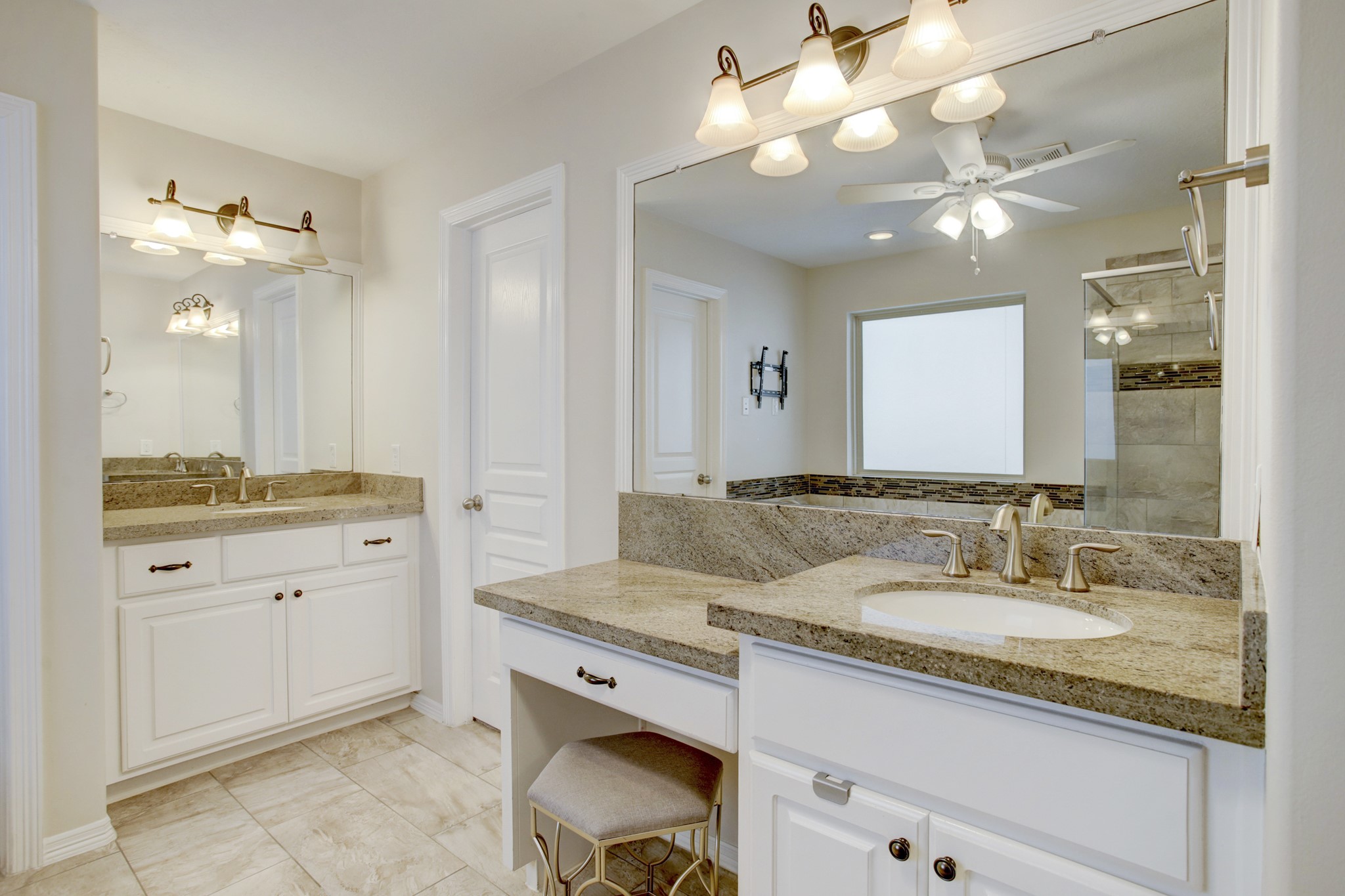 4230 Drake Street Houston, TX 77005 - Photo 18 of 38 Primary Suite Bathroom - Note the custom cabinetry, granite countertops, stainless steel hardware, framed mirrors, wall-mounted light fixtures, ceiling fan, tile floors and beautiful tile trim.