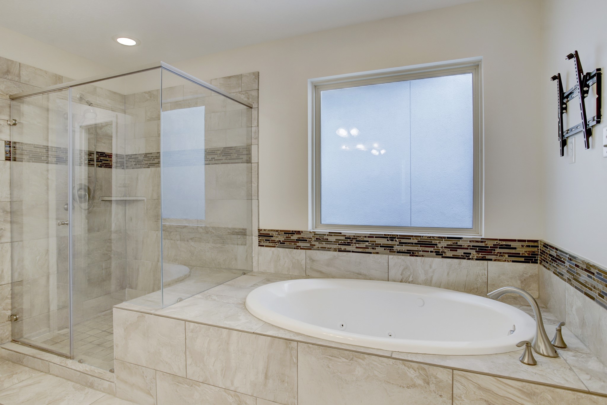 4230 Drake Street Houston, TX 77005 - Photo 19 of 38 Primary Suite Bathroom – Enjoy a spaaahhh day in the comfort of your own space. The jetted whirlpool tub is a perfect spot to enjoy a warm bath. A shower with a bench seat is adjacent to the tub. The frosted glass window provides abundant light while affording privacy.
