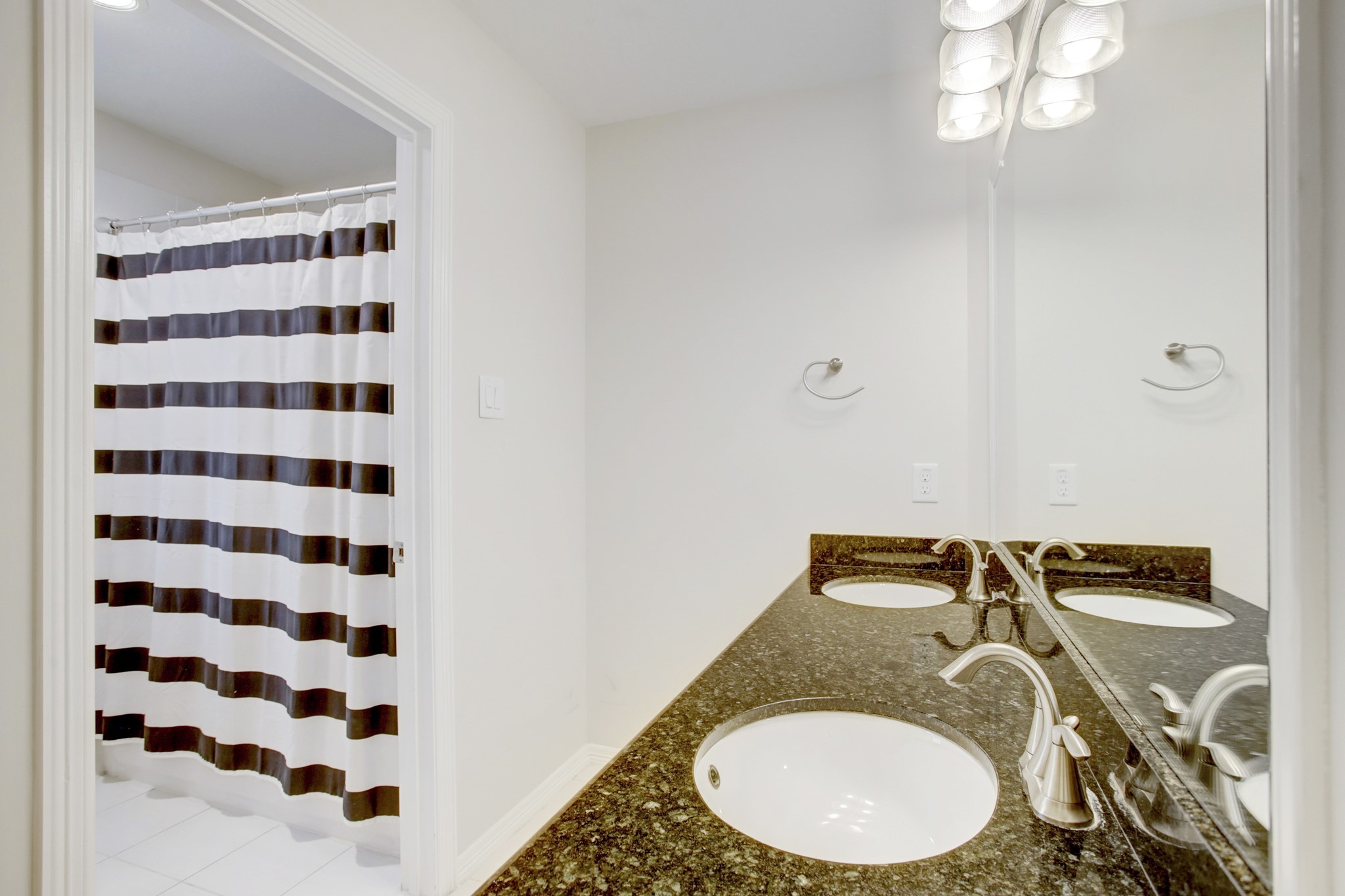 4230 Drake Street Houston, TX 77005 - Photo 23 of 38 Secondary Bathroom – This full bathroom serves both of the secondary bedrooms. Features include dual sinks, granite countertop, stainless steel fixtures, wall-mounted lights and a separate room with a water closet and tub/shower combination.