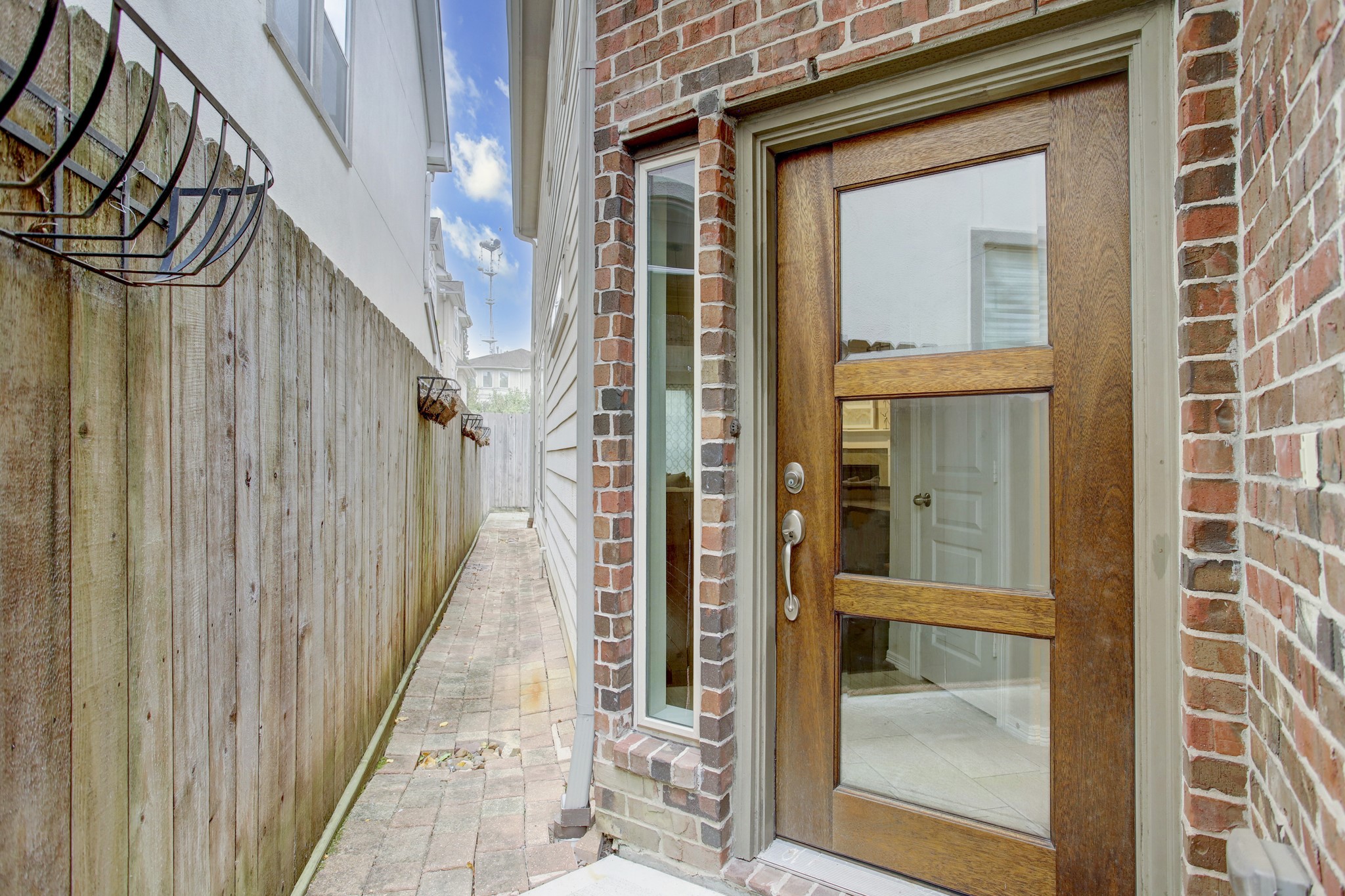 4230 Drake Street Houston, TX 77005 - Photo 3 of 38 The private wrought iron gate leads you through a low-maintenance, hardscaped side yard to the entryway.