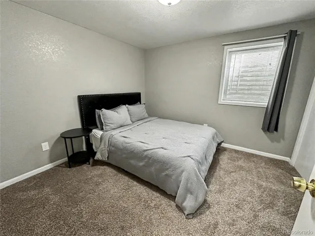 a bed sitting in a bedroom next to a window