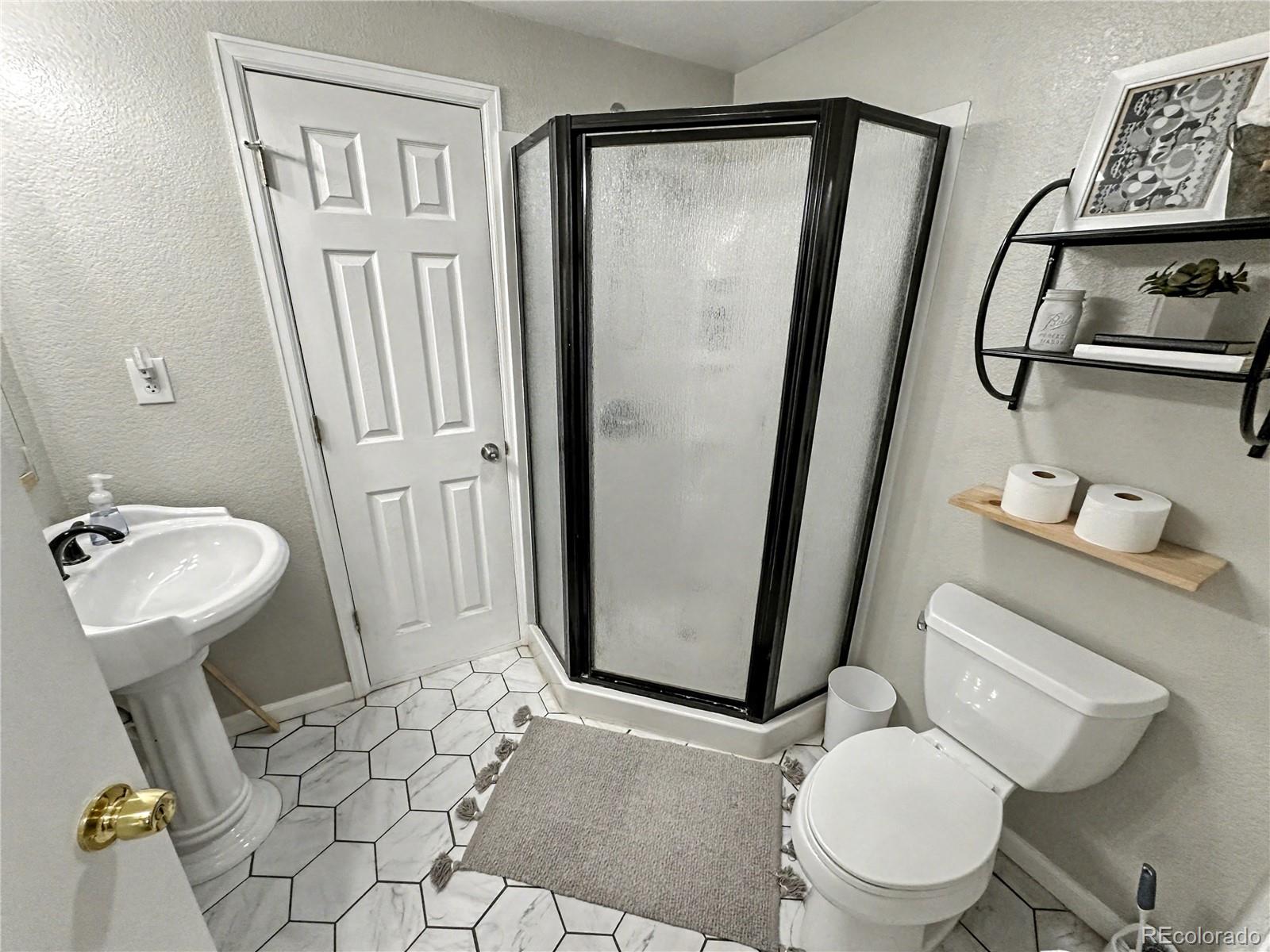 804 Nicole Road Sterling, CO 80751 - Photo 22 of 24 a white toilet sitting next to a bathroom sink