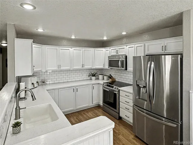 a kitchen with stainless steel appliances granite countertop a refrigerator sink and stove