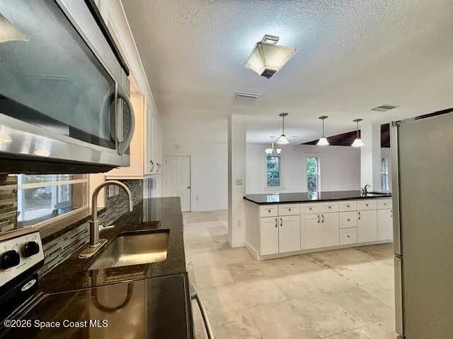 a kitchen with stainless steel appliances granite countertop a sink refrigerator and cabinets