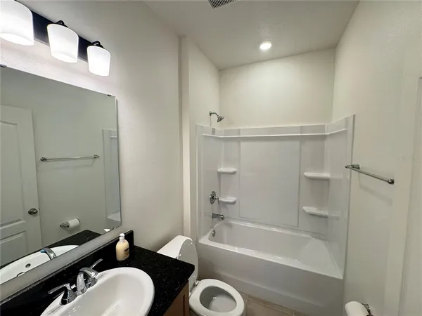 a bathroom with a tub a sink and a mirror