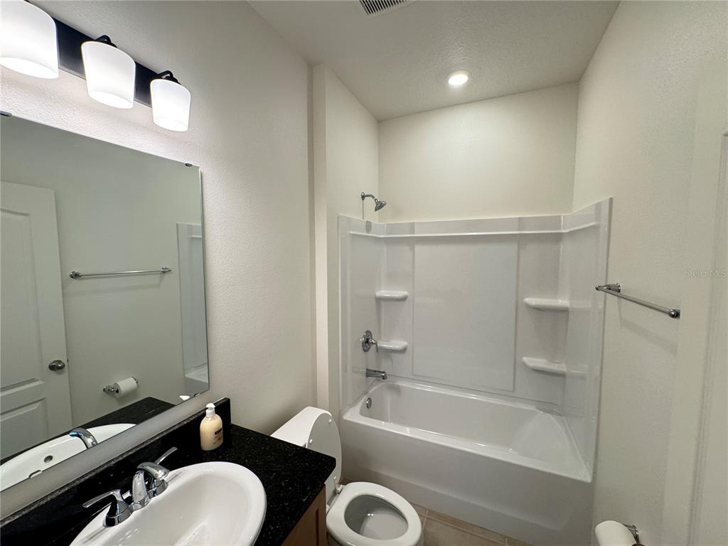 3820 Elk Blf Road St. Cloud, FL 34772 - Photo 5 of 23 a bathroom with a tub a sink and a mirror