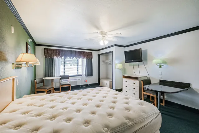 a spacious bedroom with a bed and a table in it