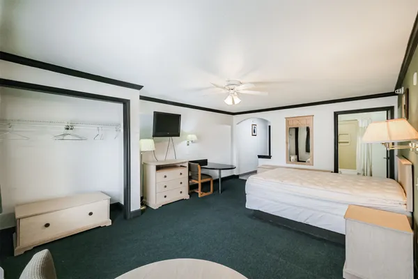 a bedroom with a bed dresser and a window