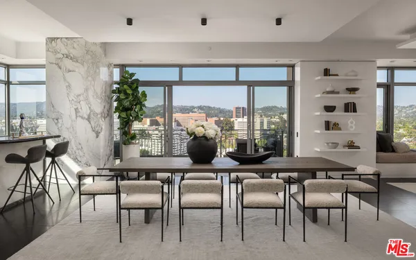 a dining room with furniture and large windows