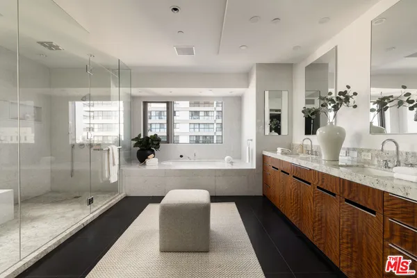 a large bathroom with a granite countertop tub a sink a mirror a shower and vanity