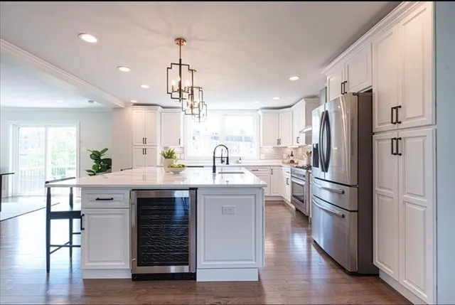 a kitchen with kitchen island white cabinets and stainless steel appliances