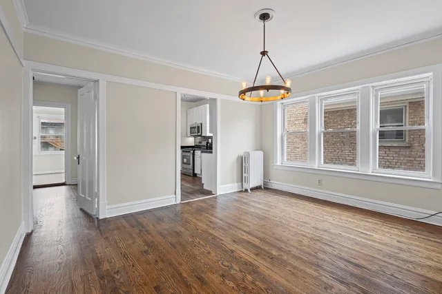 a view of empty room with wooden floor and windows