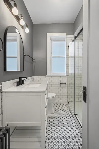 a bathroom with a sink a toilet and shower