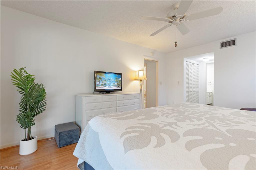 3200 Binnacle Drive, Unit C1 Naples, FL 34103 - Photo 12 of 37 a bedroom with a bed and a potted plant