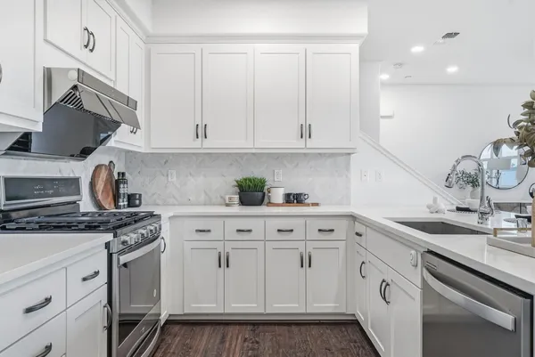 a kitchen with stainless steel appliances granite countertop a sink stove and cabinets