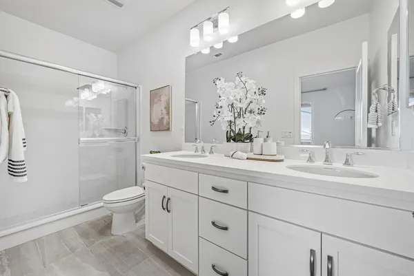 a bathroom with a sink a toilet a mirror a bathtub and shower