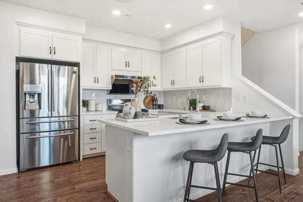 a kitchen with stainless steel appliances a refrigerator and a stove top oven