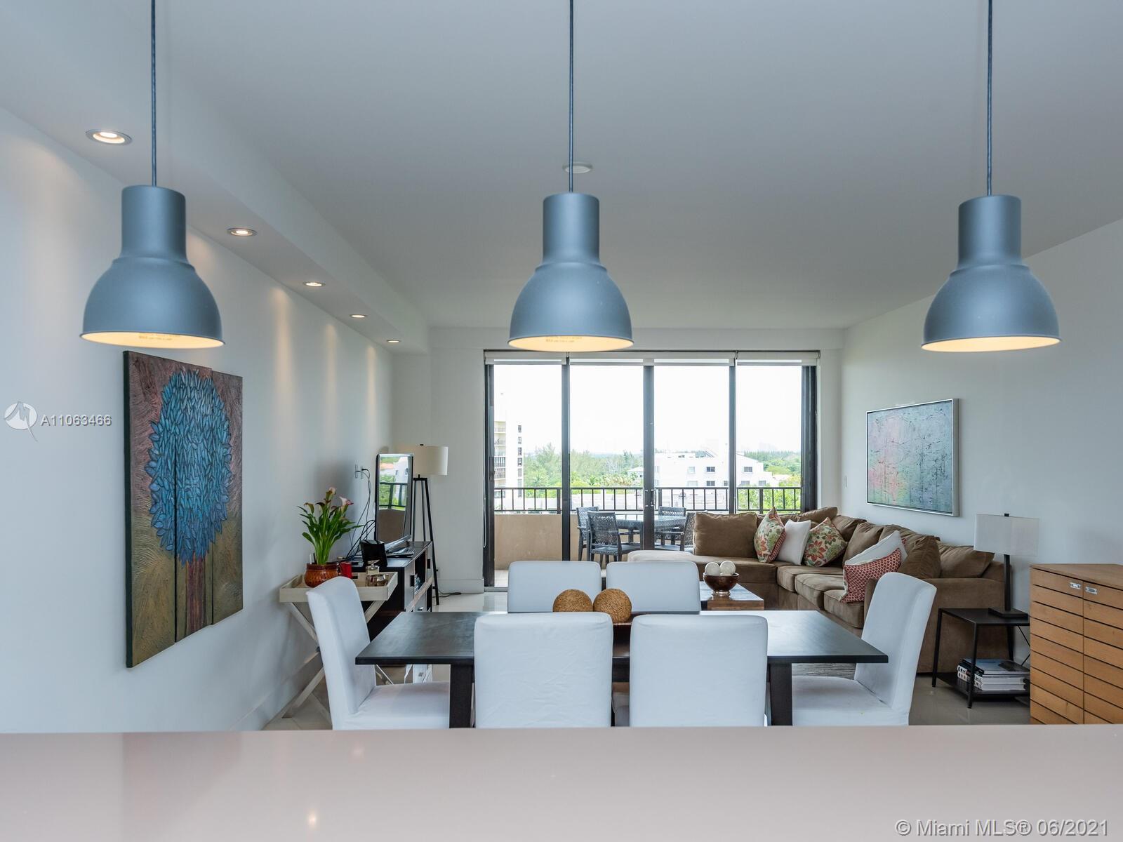 151 Crandon Boulevard, Unit 736 Key Biscayne, FL 33149 - Photo 12 of 38 a living room with furniture a window and a chandelier