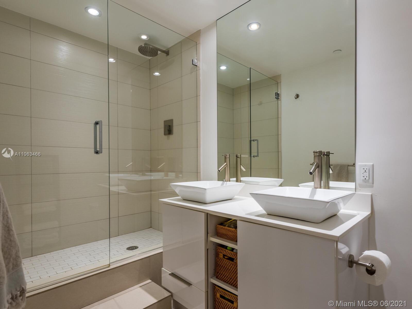 151 Crandon Boulevard, Unit 736 Key Biscayne, FL 33149 - Photo 28 of 38 a bathroom with a sink shower and a mirror
