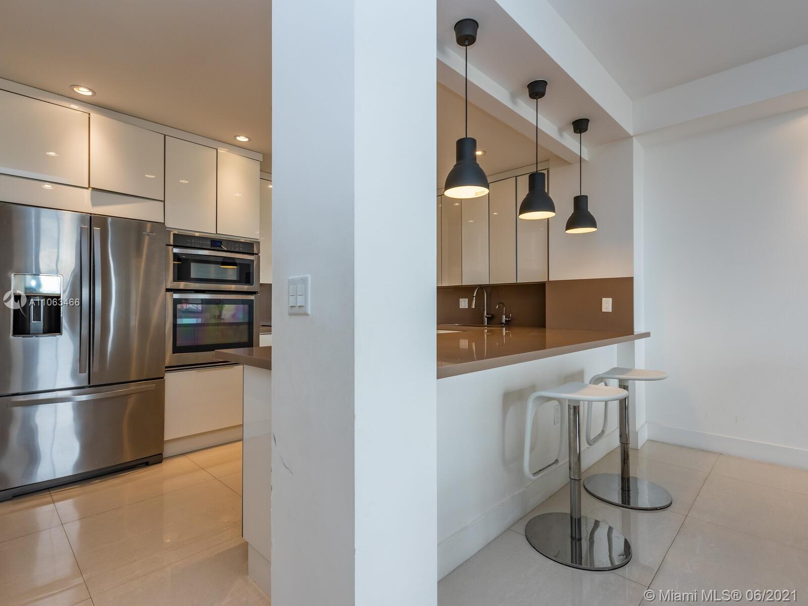 151 Crandon Boulevard, Unit 736 Key Biscayne, FL 33149 - Photo 7 of 38 a kitchen with stainless steel appliances granite countertop a refrigerator and a sink