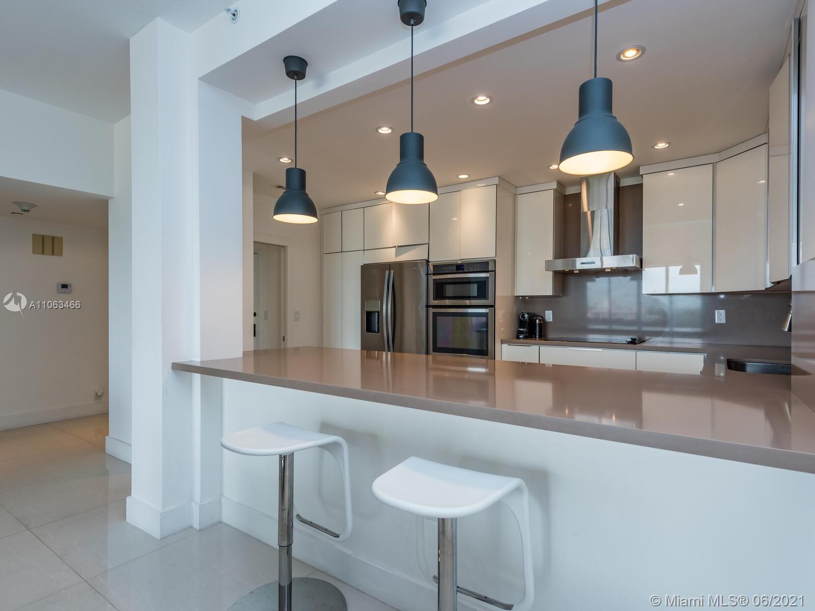 151 Crandon Boulevard, Unit 736 Key Biscayne, FL 33149 - Photo 9 of 38 a large kitchen with granite countertop a stove a sink a counter space and cabinets