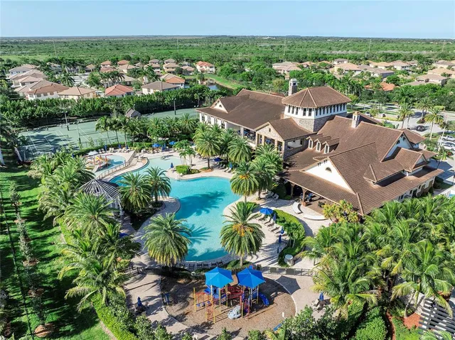 an aerial view of residential houses with outdoor space and trees all around