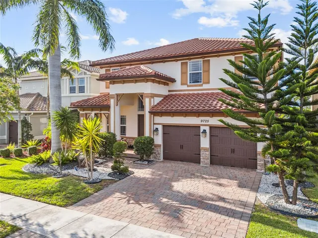 a front view of a house with a yard and potted plants