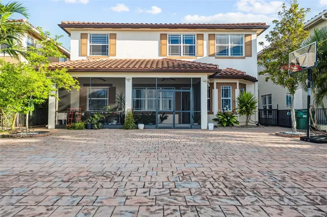a view of a brick house with a yard and large tree