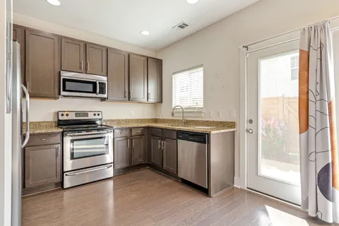 a kitchen with granite countertop a stove and a microwave