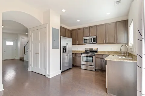 a kitchen with stainless steel appliances granite countertop a refrigerator stove and sink