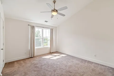 an empty room with a window and a fan