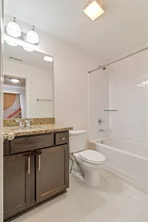 a bathroom with a granite countertop toilet a sink and a mirror