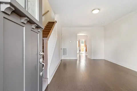 a view of a hallway with wooden floor and staircase