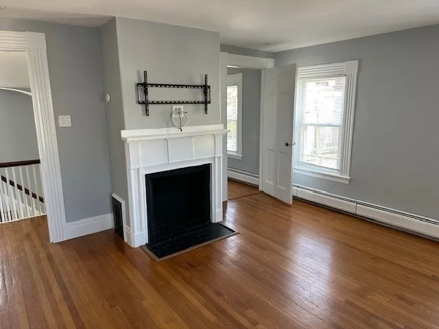 a view of a livingroom with a fireplace wooden floor and window