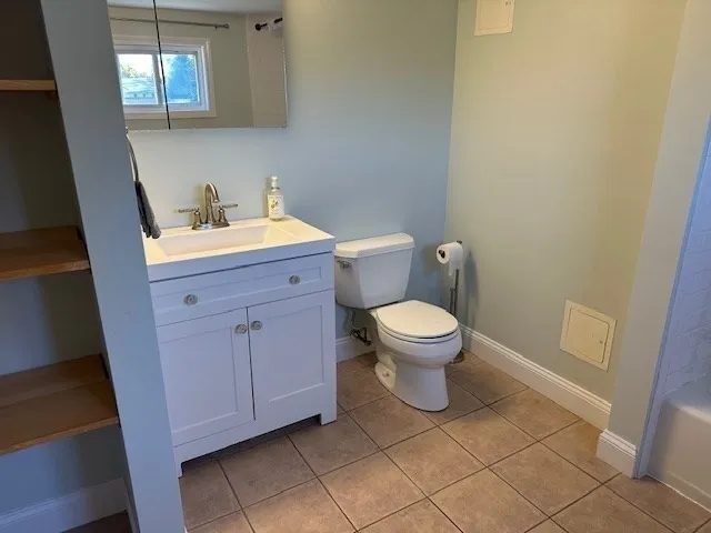 a bathroom with a toilet a sink and mirror