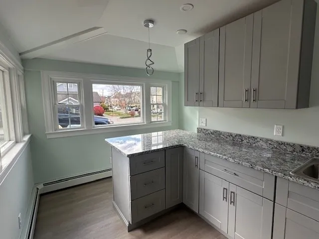 a kitchen with granite countertop cabinets a sink and dishwasher next to a window
