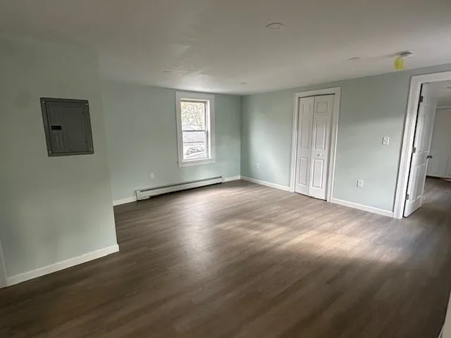 a view of a livingroom with wooden floor and a window