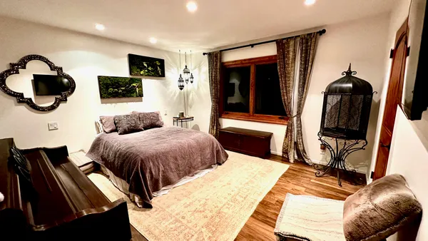 a bedroom with a bed and a flat screen tv