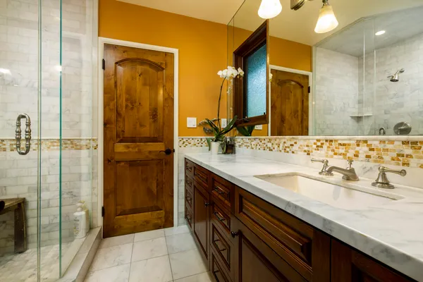 a bathroom with a granite countertop sink a mirror and a shower