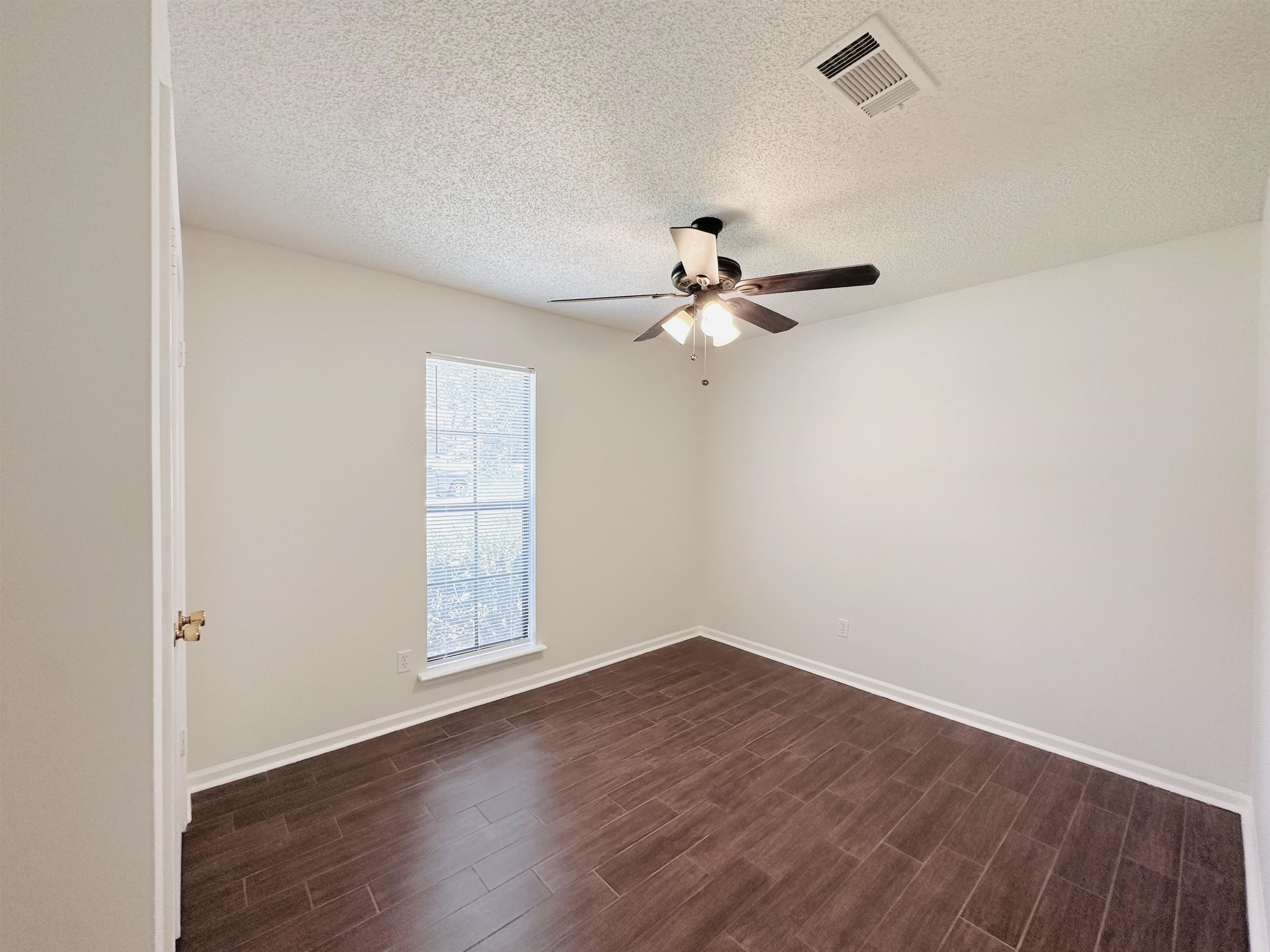 4192 Riche Road Memphis, TN 38128 - Photo 26 of 32 an empty room with wooden floor chandelier fan and windows
