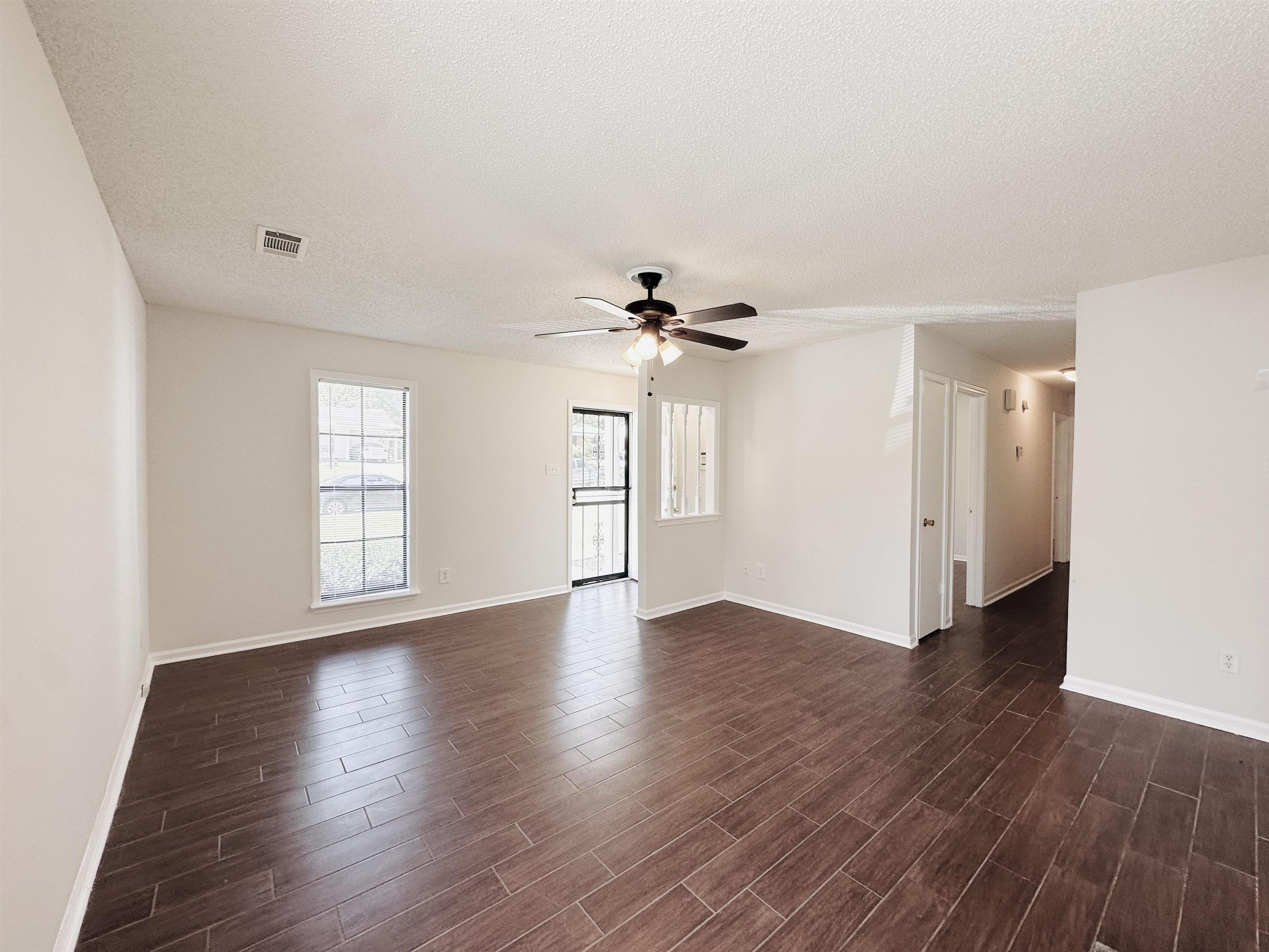 4192 Riche Road Memphis, TN 38128 - Photo 4 of 32 a view of an empty room with wooden floor and a window