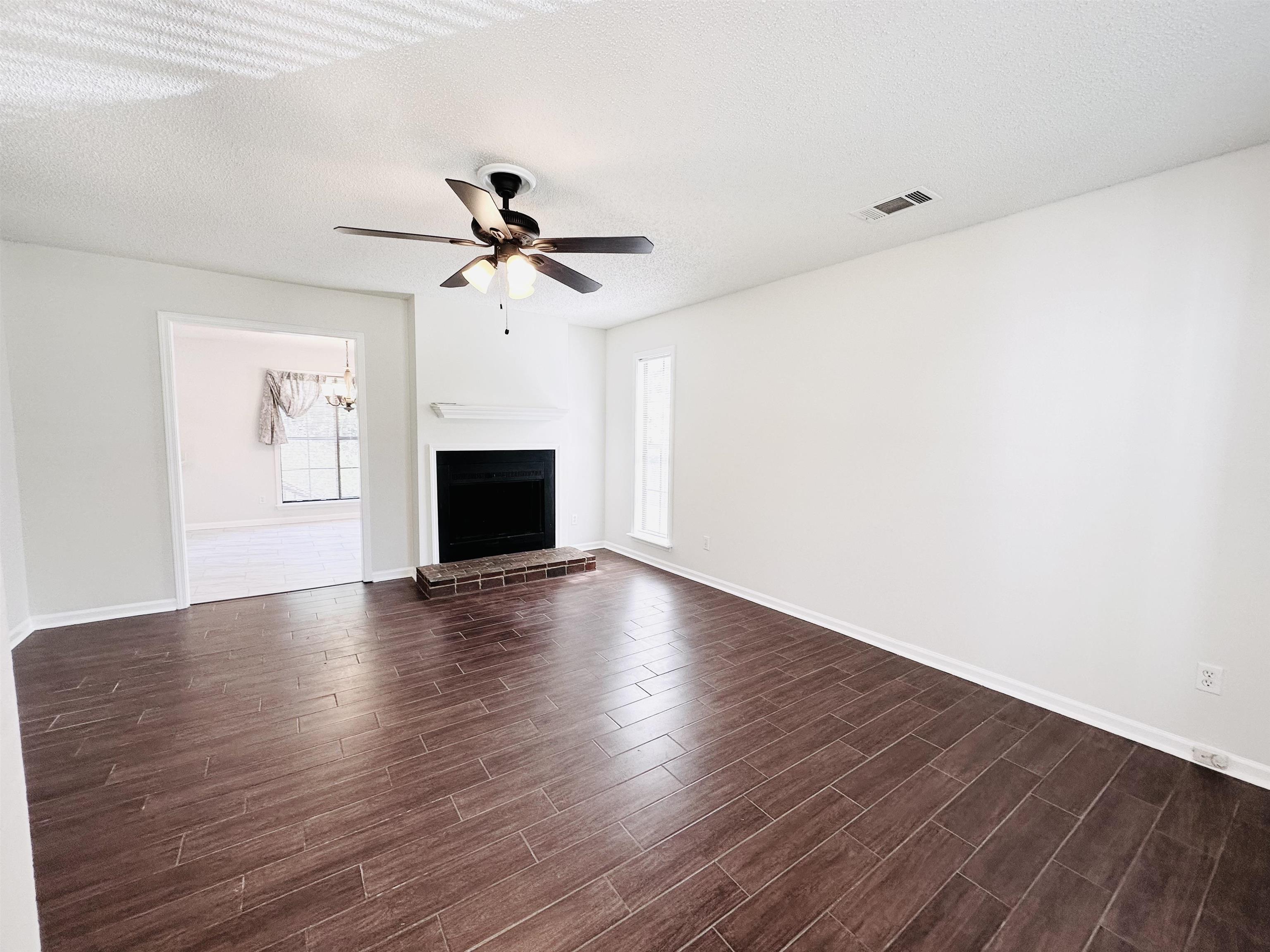 4192 Riche Road Memphis, TN 38128 - Photo 5 of 32 an empty room with wooden floor ceiling fan and windows