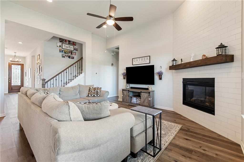 7117 Jument Drive Austin, TX 78738 - Photo 12 of 40 Living area featuring dark wood finished floors, ceiling fan, stairway, a large fireplace, and recessed lighting