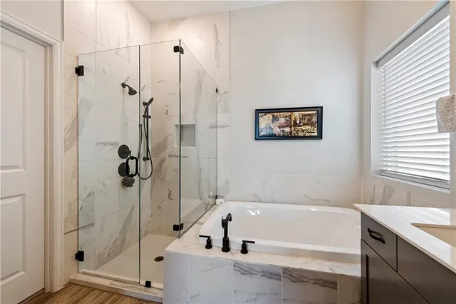 a bathroom with a shower and a bath tub